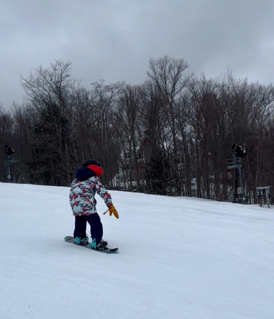 young snowboarder navigating a hill while completing a 360